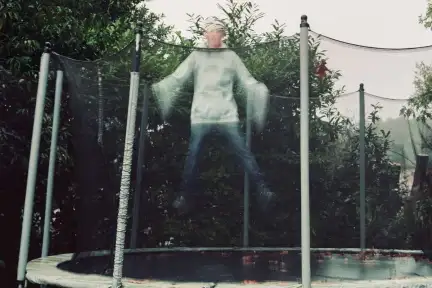 Une photographie qui fige en l'air une personne pendant son saut sur un trampoline.