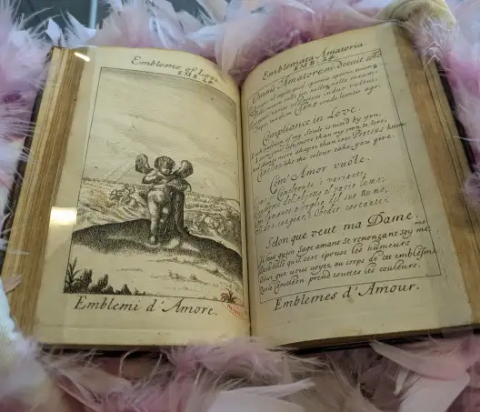 Photo d'un livre ancien ouvert avec un texte et une gravure de Cupidon