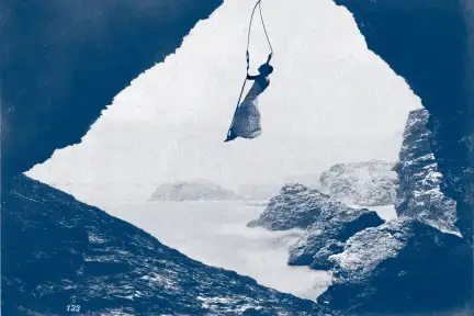 Et si, ça ne tenait qu’à un fil … Photographie prise de l'intérieur d'une grotte, ouverte sur la mer avec un paysage de rochers en second plan. Au centre, une femme de profil, vêtue d'une robe, se balance debout sur une balançoire, suspendue dans le vide