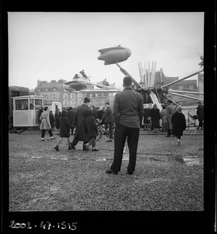 Dans les années 1960, les manèges à sensations fortes sont de plus en plus nombreux sur le Champ de Mars. Photographie prise par Charles Barmay (1909-1993) en décembre 1962 – CC BY-NC – Collection Musée de Bretagne, Rennes