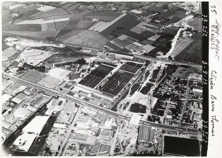 Texte alternatif : Photographie en noir d'une vue aérienne de l’usine de la Barre-Thomas, les inscriptions "35 Rennes, Citroën Barre Thomas" sont lisible sur le côté de la photographie.