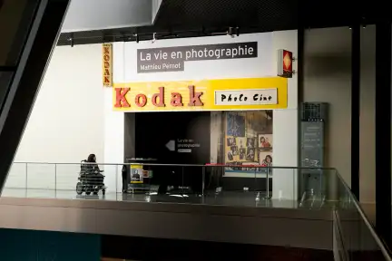 Entrée de l'exposition La vie en photographie de Mathieu Pernot, présentée au Musée de Bretagne aux Champs Libres. Plusieurs enseignes Kodak y sont disposées à l’avant.